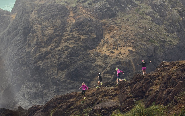 group of people trail running on a mountain