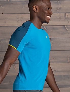 Homme souriant vu de côté portant un t-shirt de course Brooks bleu pâle