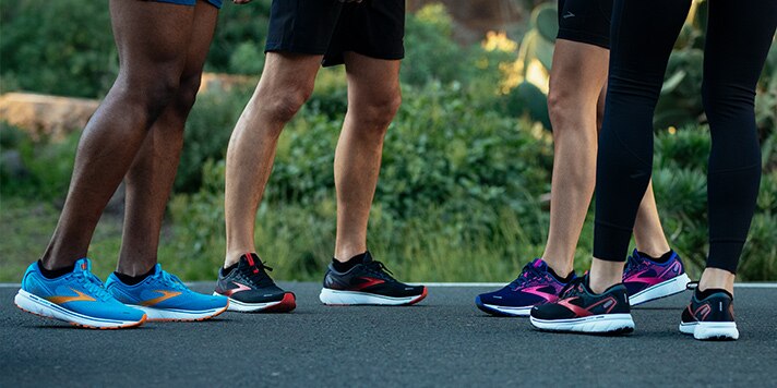 A group shot of runners on a bench, with bright new Brooks running shoes.
