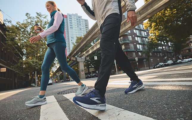 Nahaufnahme der Beine von zwei Läufern, die Brooks Beast-Schuhe mit GuideRails-Technologie tragen.