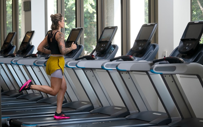 Une femme qui court sur un tapis de course dans une salle de sport
