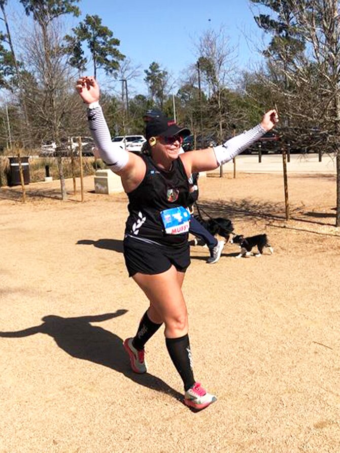 Runner with her arms up in the air