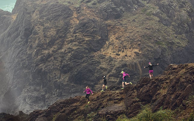 group of people trail running on a mountain