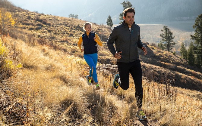 Two runnners on a meadow trail