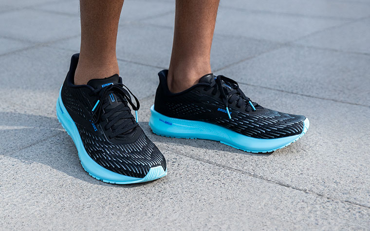 A runner in the Hyperion Tempo stands on a concrete floor.