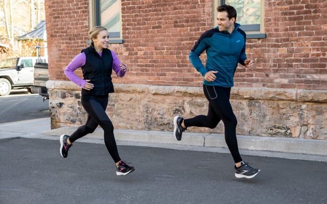 Deux runners avec un mur de briques derrière eux