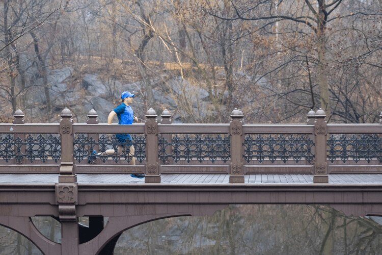 AJ running across a bridge