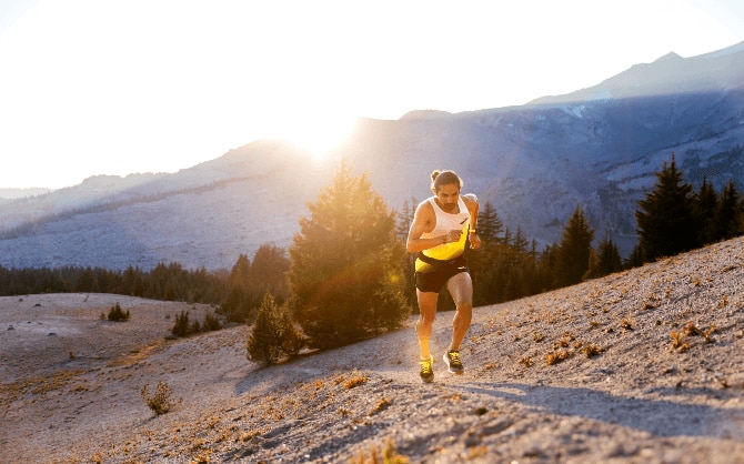 Man running up a steep trail