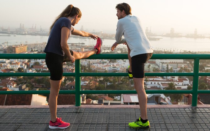 A woman and a man stretching with a view