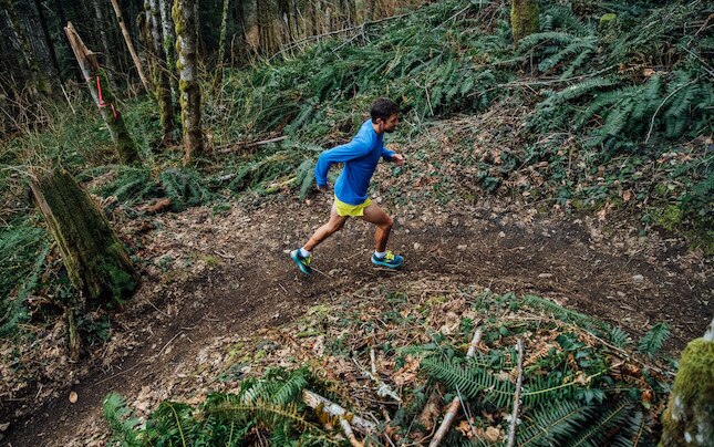 A runner rounds a bend on a trail run.