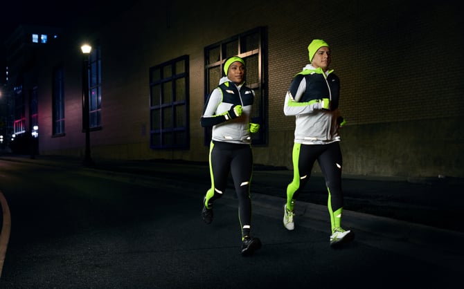 Corredores con ropa brillante en la oscuridad