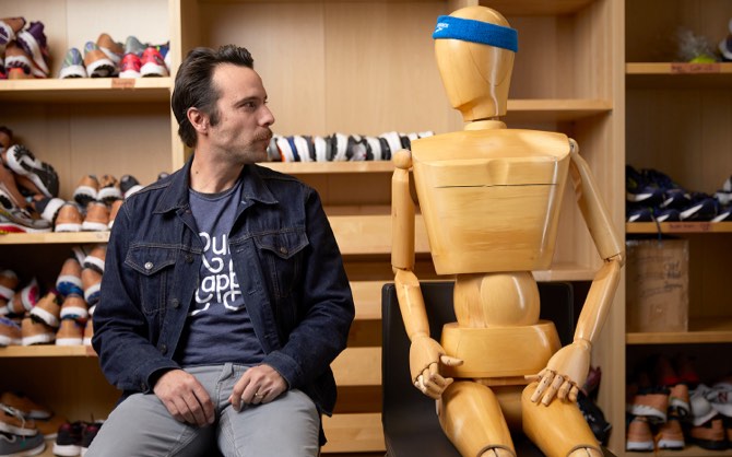 A man looking at a test dummy