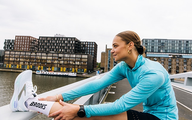 Twee hardlopers leunen op een hek voor stretchoefeningen na het hardlopen.