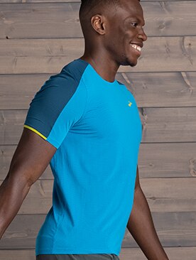 Smiling man seen from side wearing light blue Brooks running shirt