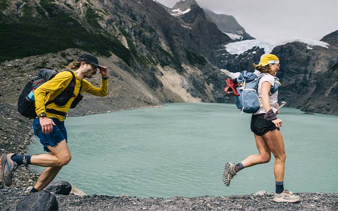 Runners next to a mountain lake