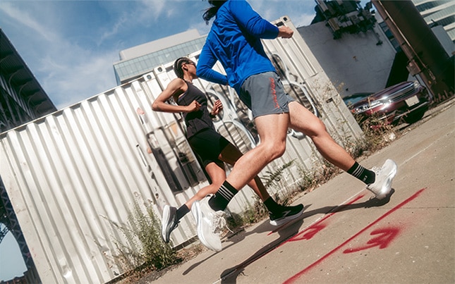 two people running in the Brooks Adrenaline GTS 25 running shoes with an industrial area in the background