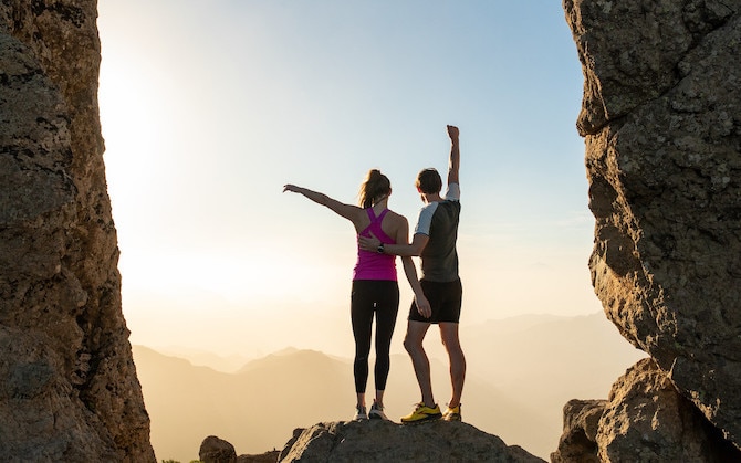 Two runners posing over a sunset