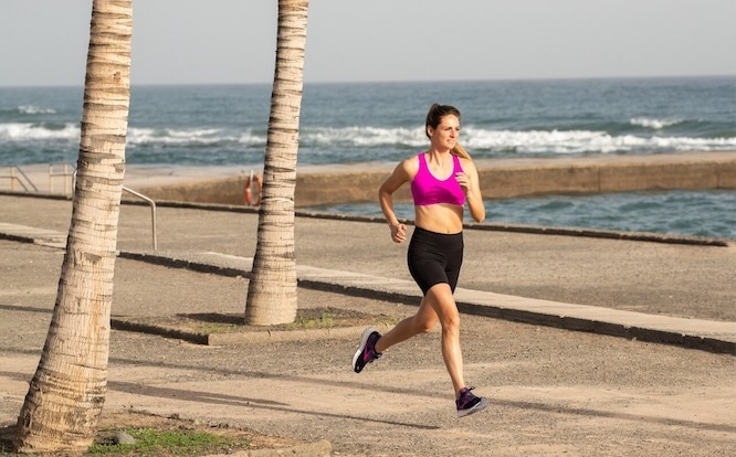 A runner on a paved road in the early morning.