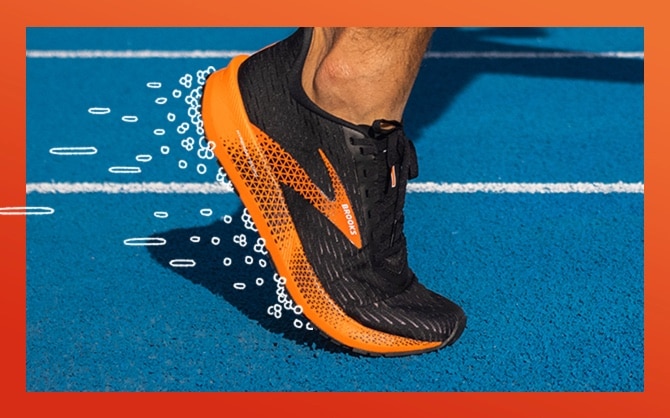 Gros plan d’un pied portant une chaussure de course Brooks entouré de bulles.