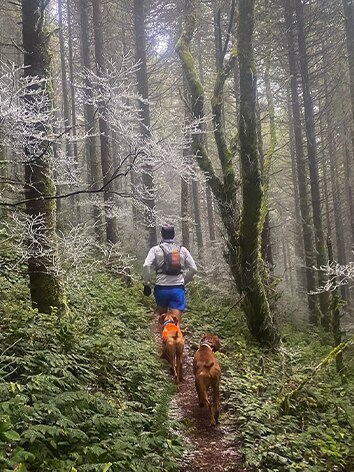 Ryan Bhark, Schuh-Entwickler bei Brooks Running, auf einem Pfad beim laufen mit seinem Hund.