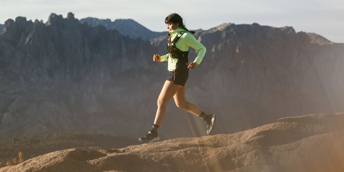 Trail runner up in the mountains while the sun is coming out