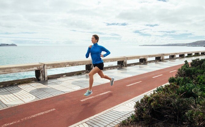 Woman running on a boardwalk by the ocean