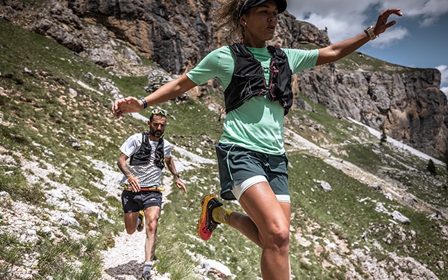 Donna che salta tra due rocce in una giornata assolata