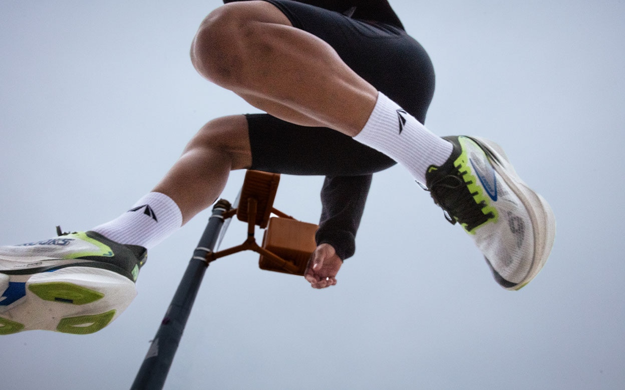 Une personne qui saute dans les airs avec les chaussures Brooks x PYNRS Hyperion Max 3