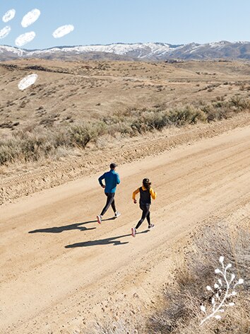 Coureurs sur une route sablonneuse avec des montagnes au loin