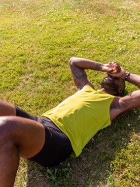 Runner fatigué allongé dans l’herbe
