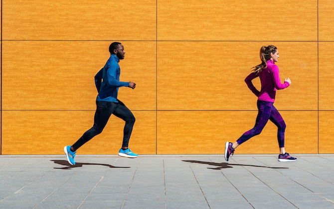 2 runners with a bright yellow wall behind them