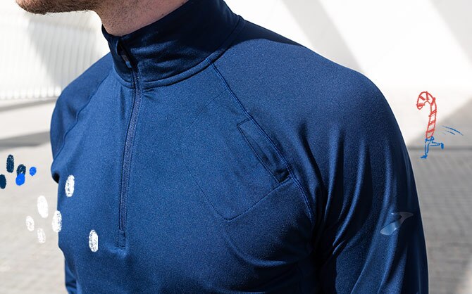 A closeup shot of a man wearing a navy Brooks half-zip.
