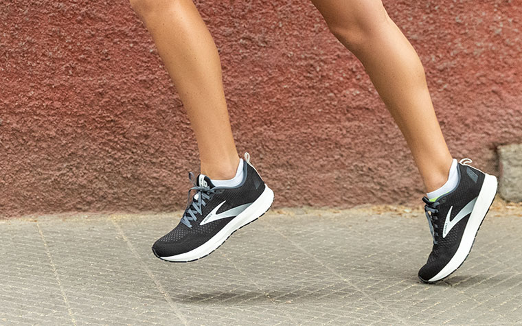A runner toes off in black and white Revel shoes.