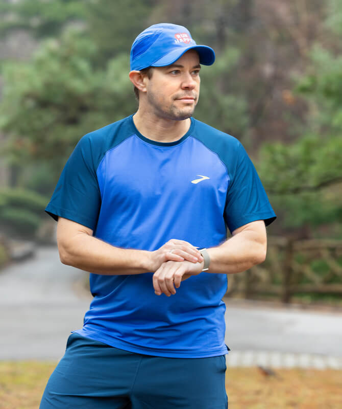 AJ schaut in blauer Brooks Ausrüstung zur Seite