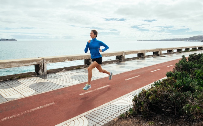 Woman running on a trail on the coast