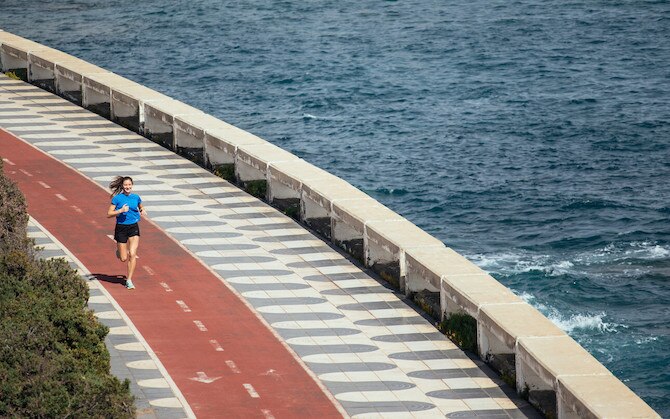 Une femme qui court sur une piste au bord de la mer