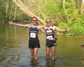Richard et Zander debout dans une rivière après une course.