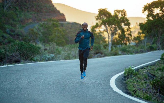 A runner runs on the curve of a rural paved road