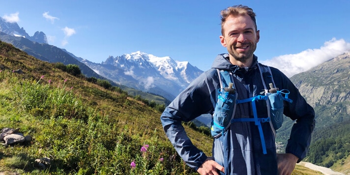 Homme avec équipement de course en sentier avec paysage montagneux en arrière-plan