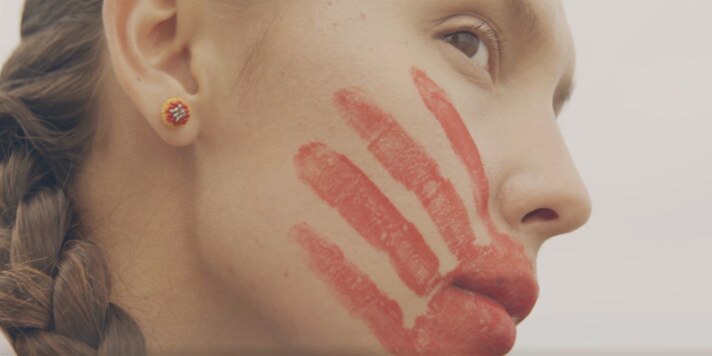 Close up of a painted red hand on Rosalie's face