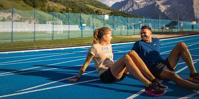 Deux coureurs assis sur une piste