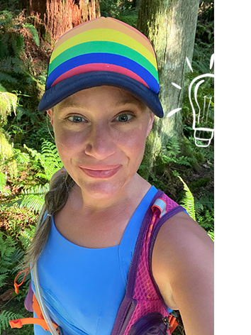 Eine Frau macht beim Laufen ein Selfie und trägt eine Kappe in Regenbogenfarben