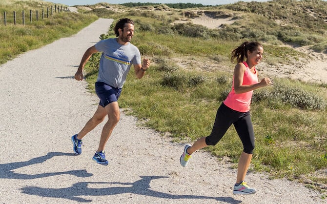 Two runners running down a trail.