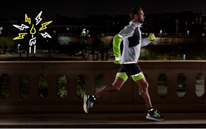 Side view of a runner running on a road at night while wearing reflective gear