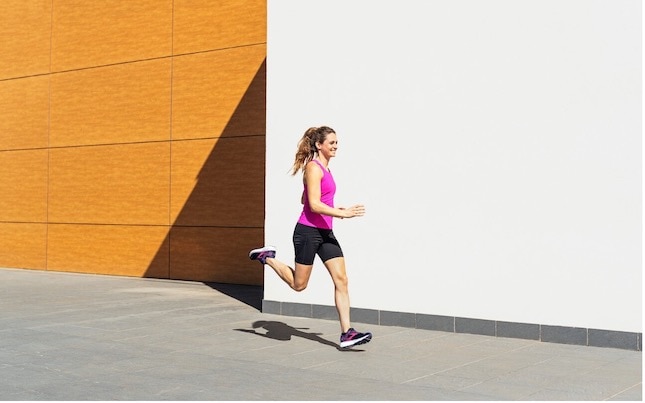 Close-up view of a runner wearing a pair of running shoes with arch support.