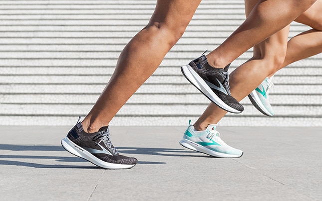 Close-up on two runners' legs at toe-off