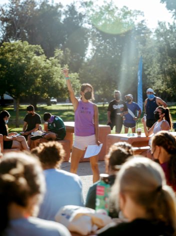 Andrea Guerra speaking in front of an outdoor crowd