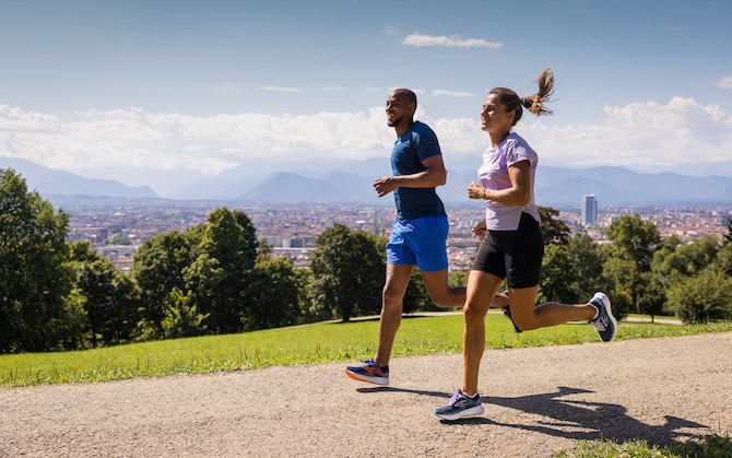 Two runners enjoy a sunny jog on a dirt path.