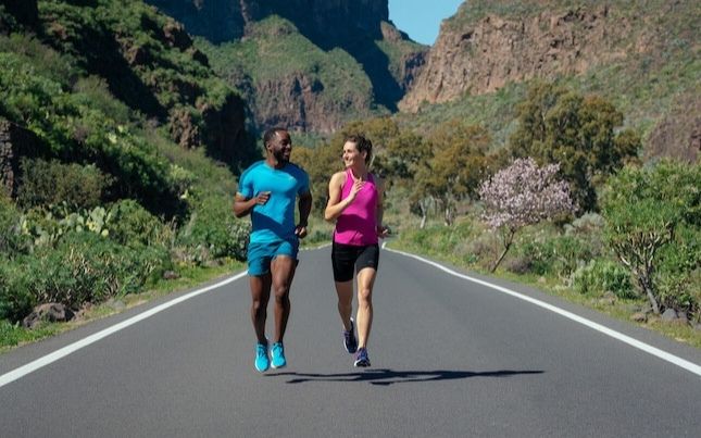 Two runners on a sunny road