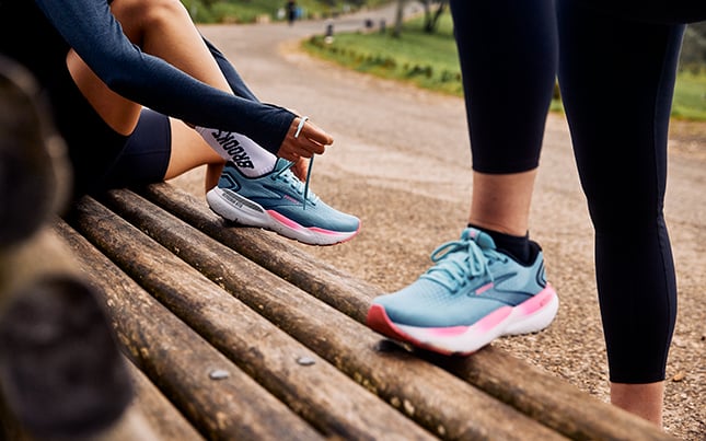 Close up photo of the legs of two runners wearing Brooks Adrenaline GTS shoes with GuideRails technology. 